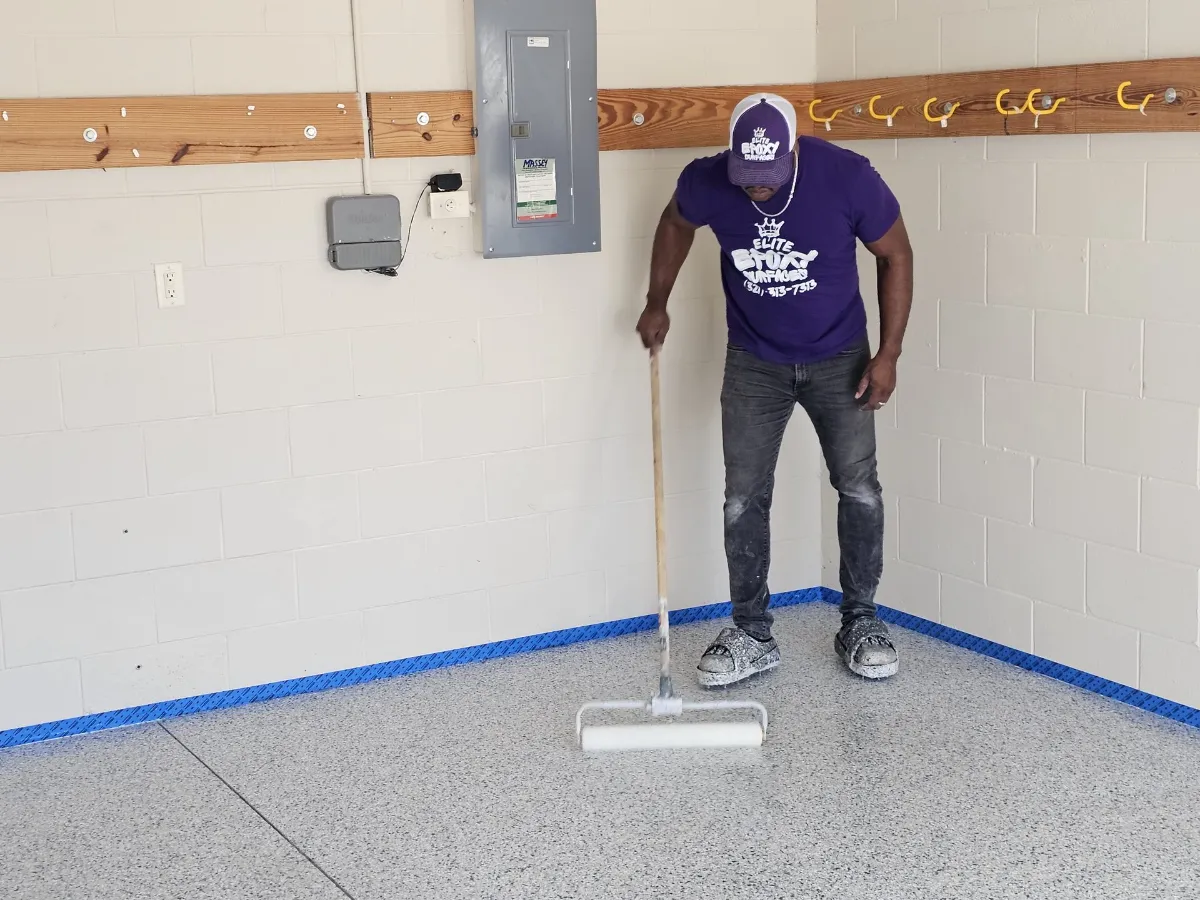 Team member in branded gear applying epoxy coating