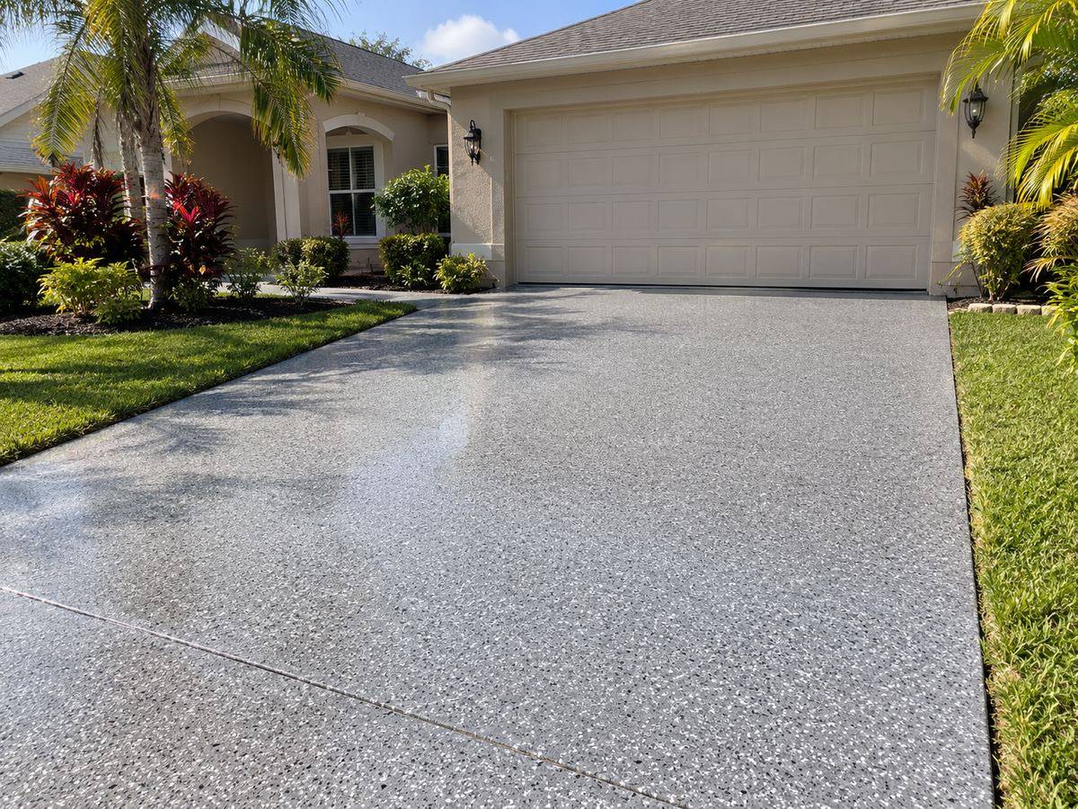 Residential driveway finished with a grey and white flake concrete coating in Central Florida